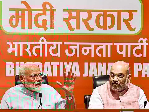 Prime Minister Narendra Modi speaks as BJP President Amit Shah looks on during a press conference at the party headquarter in New Delhi, Friday, May 17, 2019.