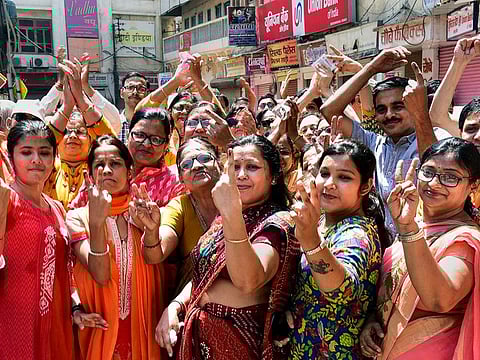 People show their inked finger after casting their vote during the seventh and last phase of Lok Sabha polls, in Varanasi, Sunday, May 19, 2019.