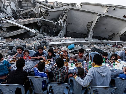 Palestinian families break their fast next to a destroyed building during recent confrontation between Hamas and Israel, in Gaza Strip on May 18, 2019, during the Muslim holy fasting month of Ramadan.