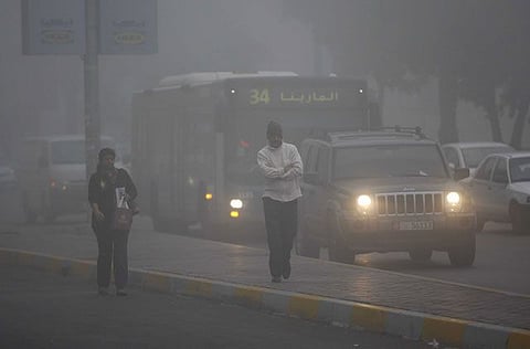 Residents during a chilly foggy morning in Abu Dhabi.
