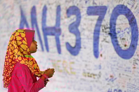 A girl looks at a board with messages of support and hope for passengers of the missing Malaysia Airlines MH370 at the Kuala Lumpur International Airport March 15, 2014.