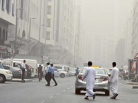 People brave the dusty weather and haze in Abu Dhabi.