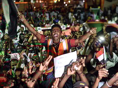 Sudanese protesters wave flags and flash victory signs as they gather for a sit-in outside the military headquarters in Khartoum on May 19, 2019.