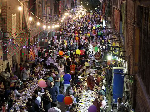 Residents of Ezbet Hamada in Cairo's Mataria district gather to eat Iftar, in Cairo, Egypt.