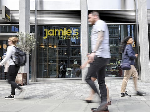 Pedestrians pass a closed-down branch of Jamie's Italian restaurants in London, UK.