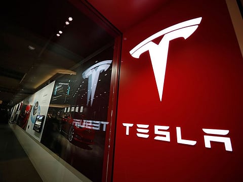 File photo: A sign bearing the company logo is displayed outside a Tesla store in Cherry Creek Mall in Denver.
