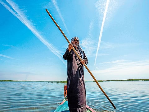 Abu Hayder, an Iraqi ecotourism guide, navigates a canoe in the marshes of the southern district of Chibayish in Dhi Qar province.
