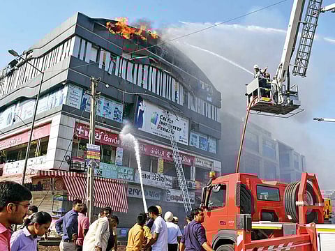 Firefighters work to douse flames on a building in Surat, in the western Indian state of Gujarat.