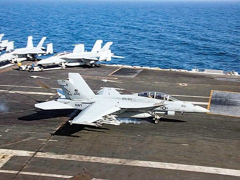 An F/A-18F Super Hornet makes an arrested landing on the aircraft carrier USS Abraham Lincoln in the Gulf of Oman