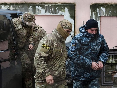 In this file photo taken on November 27, 2018 A Russia's FSB security service officer escorts a detained Ukrainian sailor to a courthouse in Simferopol, Crimea.