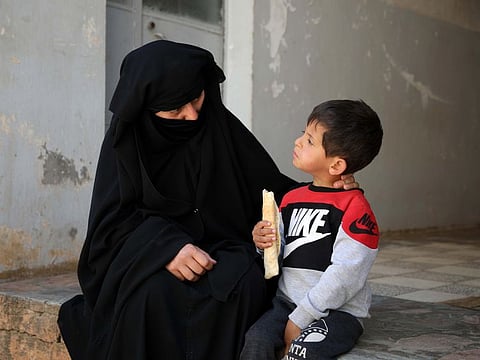 Hasna Dbeis, a 30-year-old former detainee in a Syrian-regime jail, rests with her son Mohammad outside her home in the town of Maarat Nasrin, in the rebel-held part of the Syrian Idlib province on May 14, 2019.