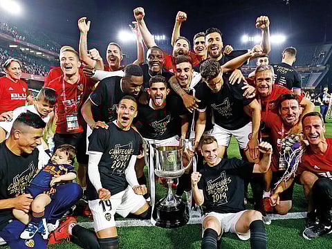 Valencia players celebrate with the trophy after winning the Copa del Rey soccer match final between Valencia CF and FC Barcelona at the Benito Villamarin stadium in Seville, Spain.