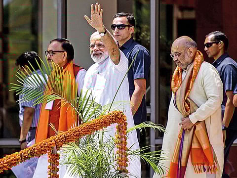 Indian Prime Minister Narendra Modi waves to supporters at the Trade Facilitation Centre and Crafts Museum after offering prayers at the famous Kashi Vishwanath temple, in Varanasi on May 27, 2019.