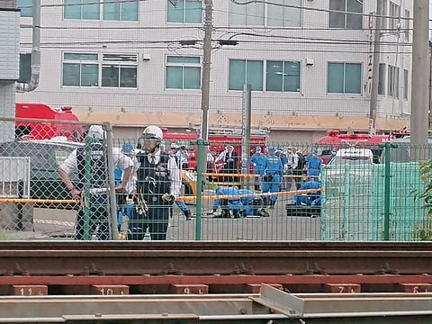 Forensics workers investigate at the scene of a stabbing at a bus stop at Kawasaki