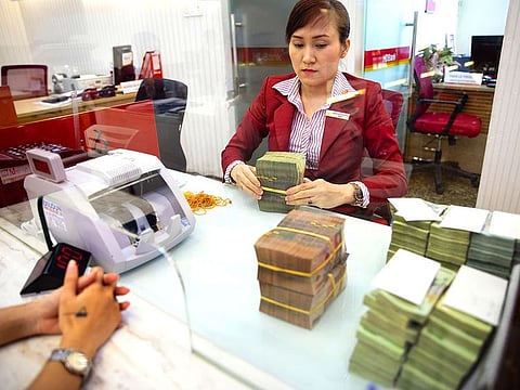 An employee counts a customer's deposit of cash at the branch in the headquarters of Ho Chi Minh City Development Joint Stock Bank, known as HD Bank, in Ho Chi Minh City, Vietnam.