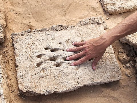 A mud brick with 3,000-year-old finger impressions.