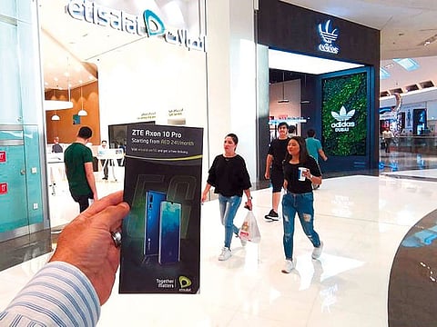 A customer checks the ZTE Axon 5G handset’s features near the Etisalat outlet at the Dubai Mall on Thursday.