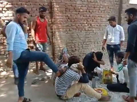 Screengrab of the video that went viral online. The four workers could been seen cowering and crying as the mob beat them and hurled abuses