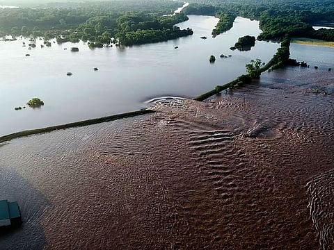 In this aerial image provided by Yell County Sheriff's Department water rushes through the levee along the Arkansas River in Dardanelle, Arkansas.