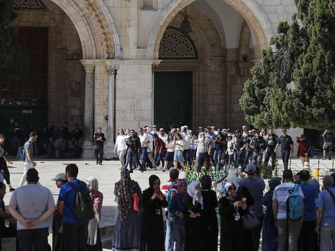 Palestinians (foreground) watch as Israeli security forces escort a group of Jewish colonists visiting the Al Haram Al Sharif (Al Aqsa Mosque compound0 in Occupied Jerusalem on June 2.