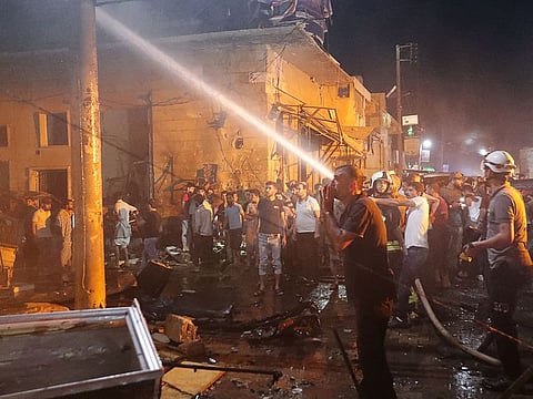 People try to extinguish a fire at the site of a car bomb blast in Azaz, Syria June 2, 2019.