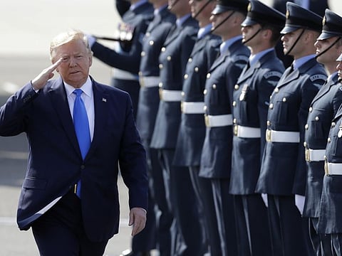US President Donald Trump salutes an honuor guard as he and first lady Melania Trump arrive at Stansted Airport in England, Monday, June 3, 2019 at the start of a three day state visit to Britain.