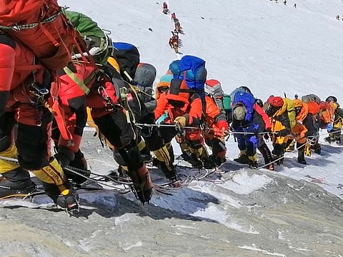 In this May 22, 2019 photo, a long queue of mountain climbers line a path on Mount Everest just below camp four, in Nepal.