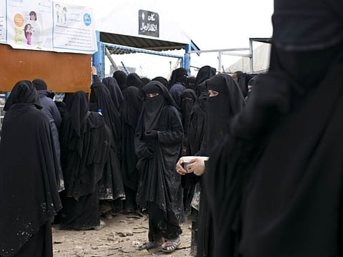In this Sunday, March 31, 2019, file, photo, women line up for aid supplies at Al-Hol camp in Hassakeh province, Syria.