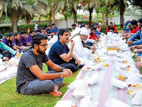 Rahul and his father Neelesh ending their fast with workers after serving them Iftar on the 27th day of Ramadan.