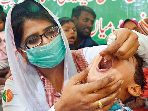 A nurse administers polio vaccine drops to a child, at Mayo Hospital in Lahore, during the launching ceremony of an anti-polio campaign.