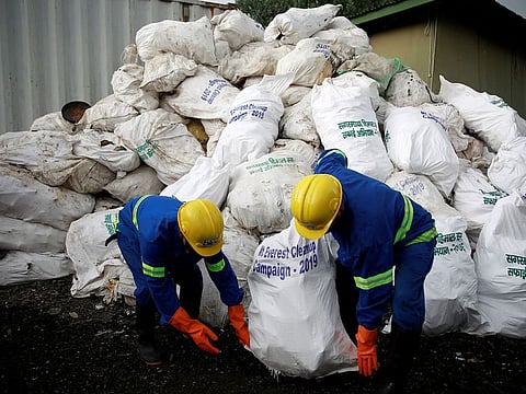 Workers from a recycling company load the garbage collected and brought from Mount Everest in Kathmandu, Nepal.