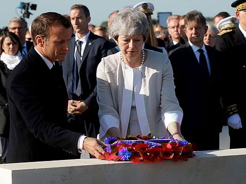 French President Emmanuel Macron and British Prime Minister Theresa May lay a wreath of flowers during a ceremony to lay the first stone of the British Normandy Memorial in Ver-sur-Mer, Normandy, northwestern France, on June 6, 2019, as part of D-Day commemorations marking the 75th anniversary of the World War II Allied landings in Normandy.