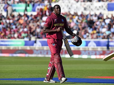 West Indies' Carlos Brathwaite walks back to the pavilion after losing his wicket for 16.