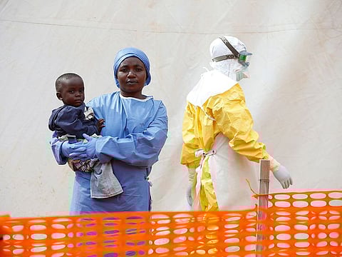 Mwamini Kahindo, an Ebola survivor working as a caregiver to babies who are confirmed Ebola cases, holds an infant outside the red zone at the Ebola treatment centre in Butembo, Democratic Republic of Congo, March 25, 2019.