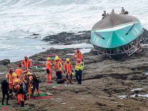 Rescuers work near a capsized boat of the National Society of Sea Rescue (SNSM) on a beach of Les Sables-d'Olonne on June 7, 2019, following the storm Miguel hit the region.