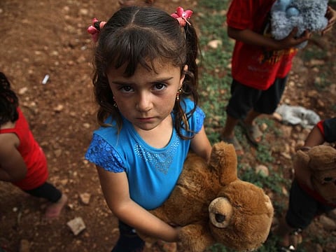 A Syrian girl carries a toy that was given to her by a Syrian man living in Finland and calling himself "The Toy Smuggler of Aleppo", after he distributed toys to children at a DIP camp for Interally Displaced Persons near the town of Aqrabat in Syria's northern Idlib province, on June 4, 2019 as Muslims around the world celebrate Eid al-Fitr, the end of the holy fasting month of Ramadan.