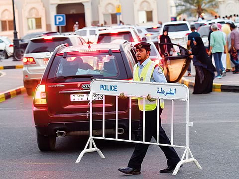 A policeman in Sharjah manages the traffic at Buhairah Corniche, even as people offered Eid Al Fitr prayers nearby.