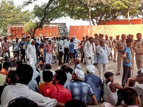 Villagers sit on 'dharna' out side the police station after the death of a child in Aligarh, Friday, June 7, 2019.