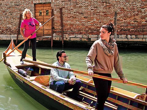 Gabriella Lazzari (left), an expert ‘vogatrici’ (rower), gives a lesson for tourists on her wooden boat in Venice.