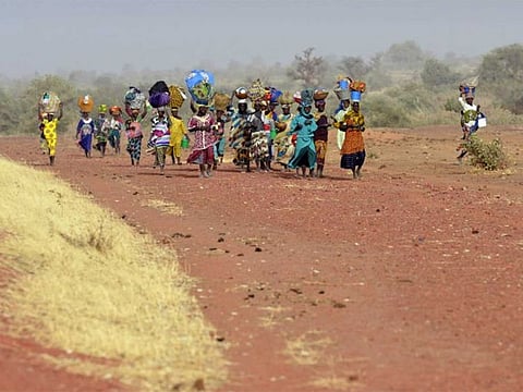 File: Women belonging to the Dogon ethnic group walk back to the village they left in central Mali after it was taken by Islamist groups in February 2013.