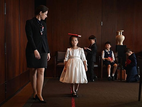 Miona Milakov (L) guiding Zoey Zhang on how to walk during an etiquette and manners class in central Shanghai.