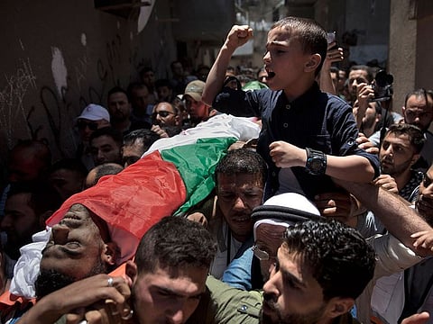 Mourners carry the body of Palestinian paramedic Mohammed Al Jadili, 36, who died from an earlier injury by Israeli fire during a Friday's protest.