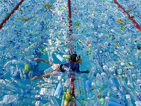 A child swims in a pool filled with plastic bottles during an awareness campaign in Bangkok.