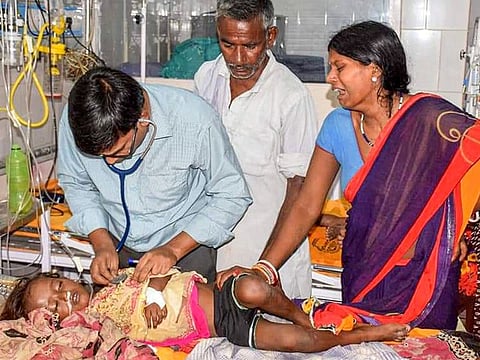 Muzaffarpur: A doctor treats a child showing symptoms of  Acute Encephalitis Syndrome (AES) at a hospital in Muzaffarpur, Tuesday, June 11, 2019.