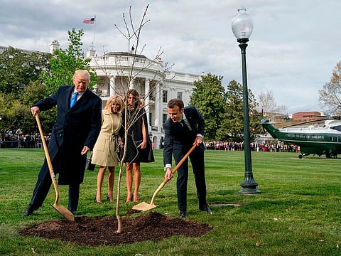 In this April 23, 2018 file photo, Melania Trump, second right, and Brigitte Macron, second left, watch as President Donald Trump and French President Emmanuel Macron participate in a tree planting ceremony on the South Lawn of the White House in Washington.