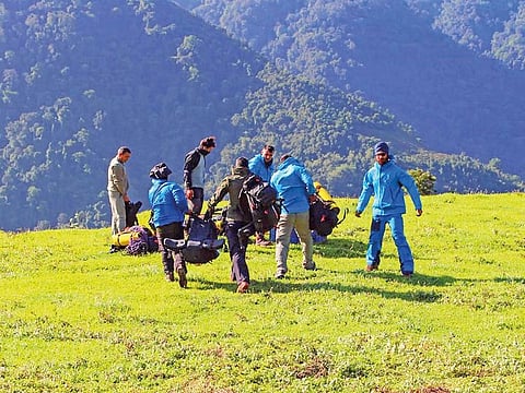 Members of a rescue team prepare to camp overnight, due to difficult terrain and weather, and move to the AN- 32 crash site near North Lipo on Wednesday.