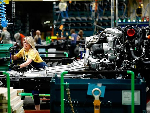 Line workers assemble the chassis of full-size General Motors pickup trucks at the Flint Assembly plant in Flint, Michigan.