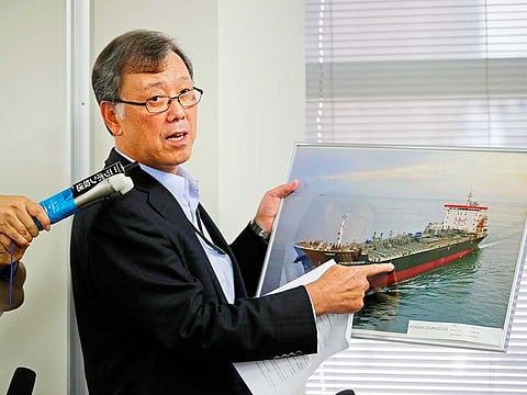 Yutaka Katada, president of Kokuka Sangyo Co., the Japanese company operating one of two oil tankers attacked near the Strait of Hormuz, shows a photo of the attacked oil tanker during a news conference in Tokyo