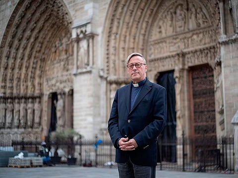 The Notre-Dame de Paris cathedral's rector Patrick Chauvet poses on June 13, 2019 in front of the cathedral which will host in three days its first mass since a fire ravaged the Paris landmark almost two months ago.