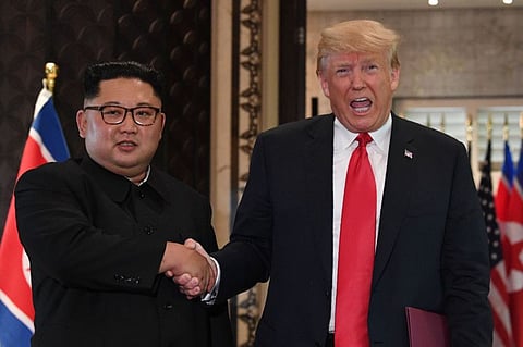 US President Donald Trump and North Korea's leader Kim Jong-un shake hands following a signing ceremony during their historic US-North Korea summit, at the Capella Hotel on Sentosa island in Singapore on June 12, 2018 . They had pledged change and progress. But now they are gripped by diplomatic recriminations after a failed second meeting in Hanoi.